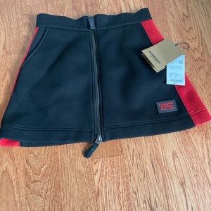 BURBERRY BLACK NEOPRENE MINI SKIRT in black with red stipe on each side.